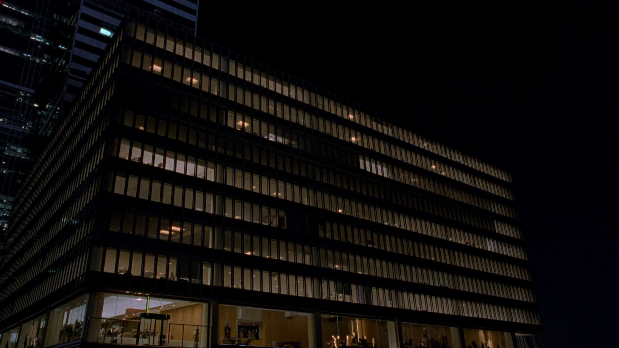 Glass office tower facade lit at night