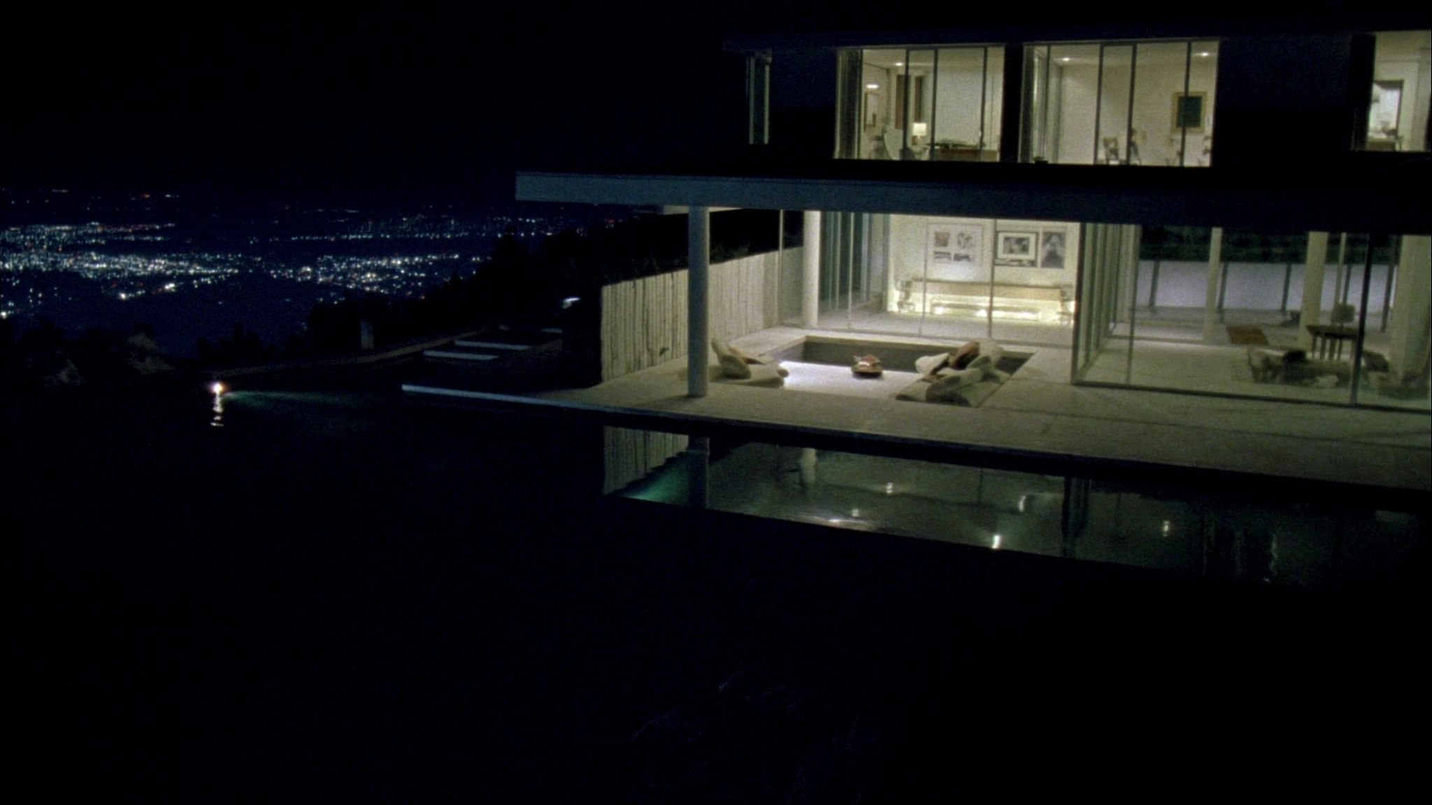 Modern hillside glass villa at night