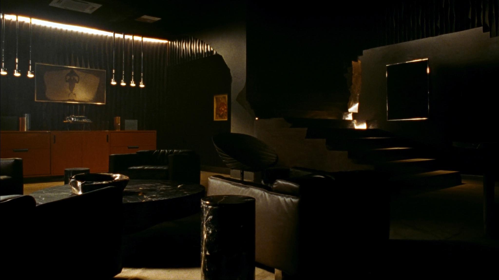 Dark luxury lounge interior with black marble, brushed steel and leather seating