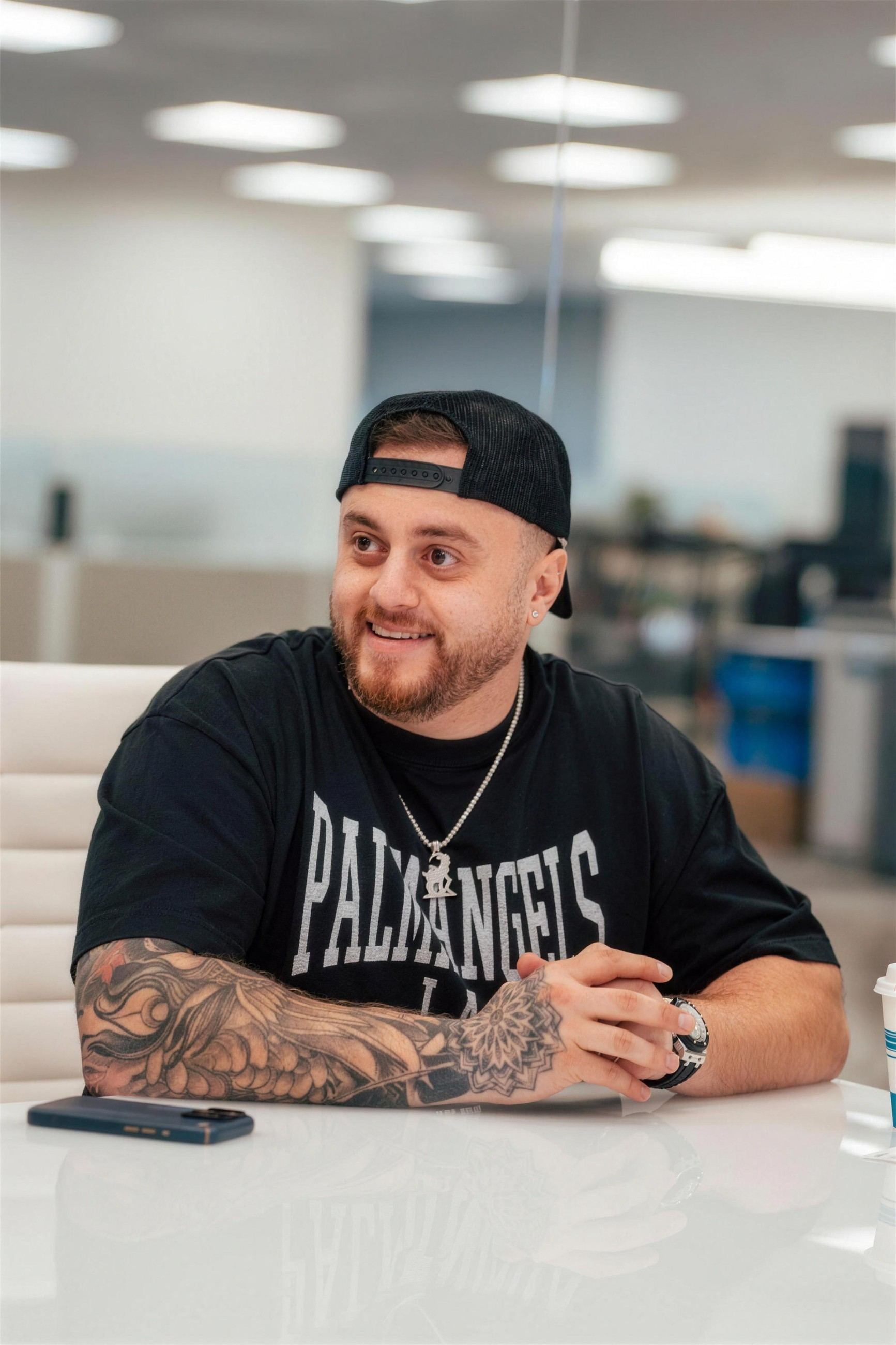 Milad Shamoun seated in the Loan Goat office in a backwards cap